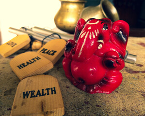 Red ganesh deva sculpture portrait picture with pots and Bells in the background. Lord Ganesh is one of the important and prestigious figure in Hindu mythology