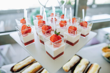 Milk dessert with strawberry jam and fresh strawberries in a restaurant at a wedding ceremony. Candy bar