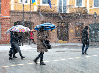 Busy city people going along the street in winter snowy day