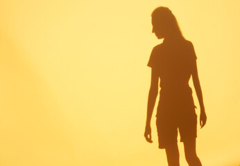 Woman silhouette over orange wall