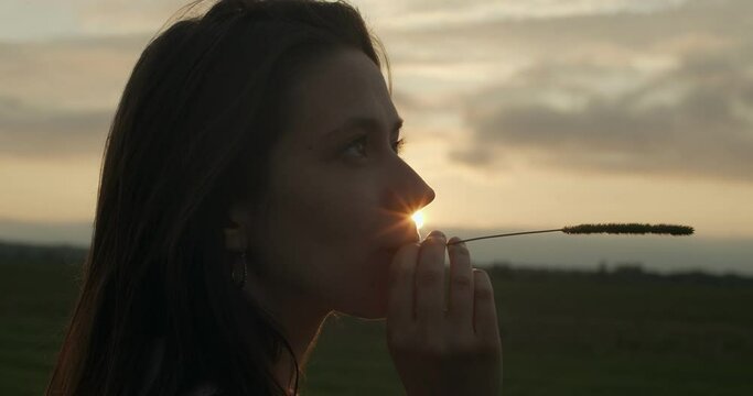Close up side portrait of young woman posing outdoors on natural sunset background. Macro profile of female face thinking of future life copy text space. Facial cosmetics care. Trust hope belief