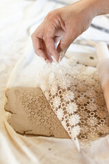 master uses fabric for texture on clay, close-up