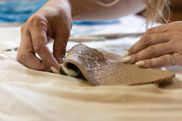 master uses fabric for texture on clay, close-up