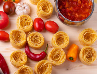 dry pasta rolls and ingrediets for making a tomato sauce