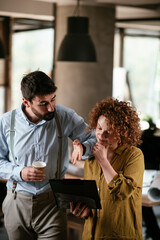 Colleagues in office. Businesswoman and businessman discussing work in office. Two friends in working together..