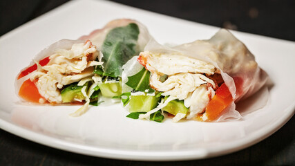 Rice spring rolls with crab meat and vegetables on a white plate. Vietnamese seafood cuisine. Food banner format