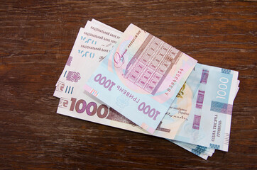 New 1000 hryvnia banknotes on a wooden table. Financial concept.