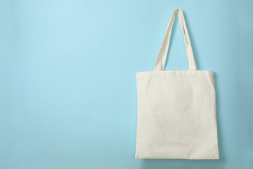 Cotton bag on blue background, space for text