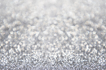Obraz premium Abstract glitter christmas silver background. Shimmer bright background with bokeh defocused silver lights. Shiny gradient with copy space