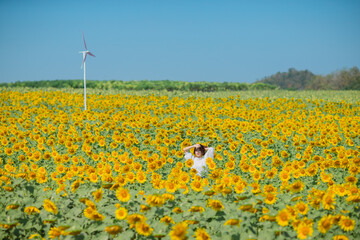 Beautiful smile asian young woman in sunflower field. Happy girl in sunflower field. Portrait of asian woman in sunflower field when traveling on vacation.