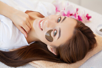 Obraz na płótnie Canvas Spa treatment, beautiful woman with facial eye patch at beauty salon.