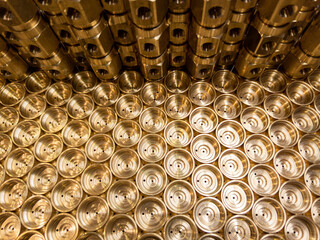 an abstract industrial close-up background of shiny brass metal threaded hexagonal fitting parts