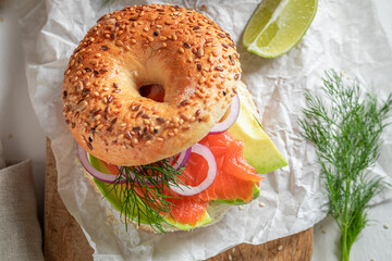 Delicious bagel with avocado, salmon and dill for healthy breakfast