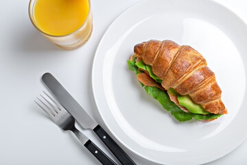 Sandwich croissant in plate for breakfast close up