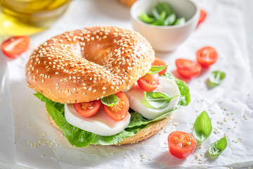 Fresh bagel with cheese, tomatoes and basil for healthy lunch