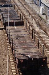 The composition of the railway wagon - platforms for large objects. An old-type platform. A metal structure with a wooden floor.