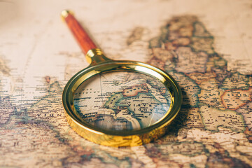 Magnifying glass on a vintage world map. Close up.