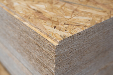 OSB sheets are stacked in a hardware store. Building material wood