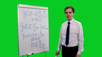 Intelligent young man explaining equations in physics on whiteboard against green screen...