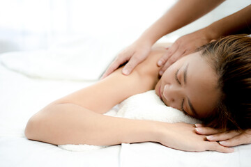 Beautiful woman lying face down She was relaxed as the massage therapist kneaded her shoulders. Spa massage concept.