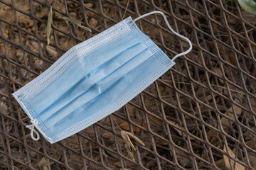  Used face mask was left on a steel grate, closed the drain.