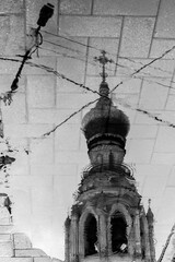 Reflection of old orthodox bell tower with golden dome