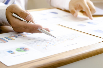 A businessman looking at the company's earnings data sheet in his office.