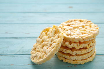 Corn round crispbread, crunchy multigrain cereal seeds on blue wooden background, healthy eating
