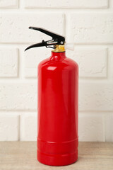 Fire extinguisher on white brick wall with clipping path. Vertical foto.