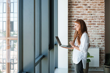 Image of redhead businesswoman making video call on laptop