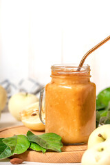 Fresh natural organic apple smoothies in a glass jar. Light background, free space for background.