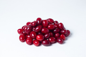 Dogwood on a white background. Fresh red dogwood lies in a small heap. Gathering the summer harvest.