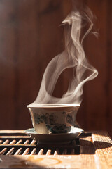 Chinese teacup with black tea and cloud of vapor