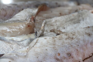 fish fins and scales of fresh Pollock on the background of a metal table