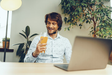 Fototapeta premium Bearded man using his laptop while drinking glass of beer