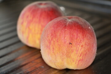 ripe peaches on a metallic silver background