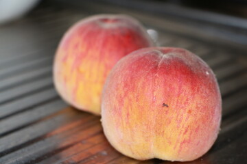 ripe peaches on a metallic silver background