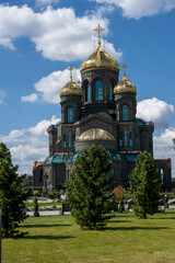 Fototapeta premium panoramic view of a dark temple with golden domes against a background of gray clouds