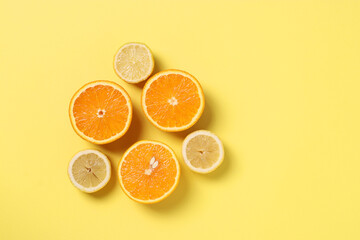 Composition in the style of minimalism of halves lemons and oranges on yellow background with space...