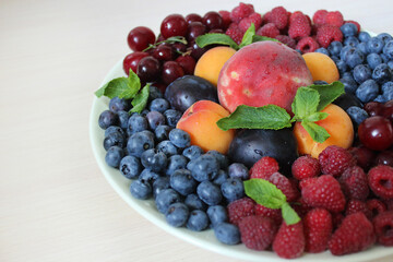 Summer mix of berries on a white plate .Texture or background