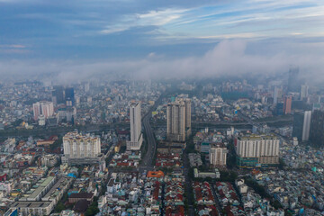 Aerial view of early morning fog in built-up urban area with high rise buildings and background obscured by low cloud