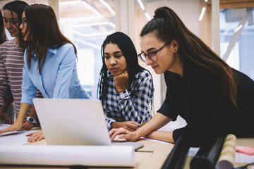 Professional colleagues working in team cooperating completing project and watching online videos on break.Diversity group of employees having fun together enjoying collaboration process in office