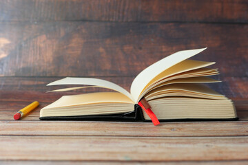 open book and a pencil on wooden table 