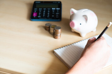 Asian men sit hand taking note by pencil and plan for his financial saving. Retirement or tax saving plan with copy space for text.