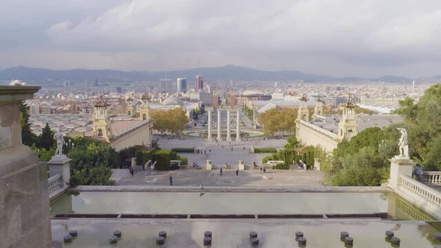 A huge long view of The city with The Venetian Towers and Magic Fountains with tourist on Avinguda de la Reina Maria Cristina at its junction with Pla&ccedil;a d'Espanya in Barcelona, Catalonia, Spain.