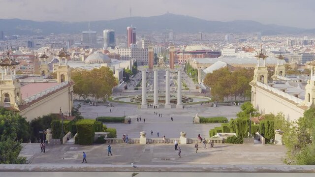 A long view of The Venetian Towers and Magic Fountains with tourist on Avinguda de la Reina Maria Cristina at its junction with Pla&ccedil;a d'Espanya in Barcelona, Catalonia, Spain.