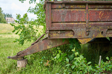 Old rusty tractor-trailer front placed on wooden block 