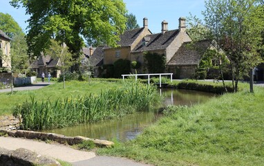 Fototapeta na wymiar Picturesque Cotswold cottages beside the River Eye in Lower Slaughter, Gloucestershire, England.