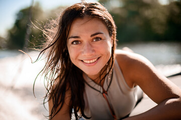 Portrait of handsome woman with brown wet hair on blurred background beach