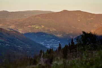 Farm on the countryside of Norway. Warm light in golden hour. Long distance. 